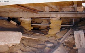 A crawlspace with dirt and stone piers underneath Taliesin
