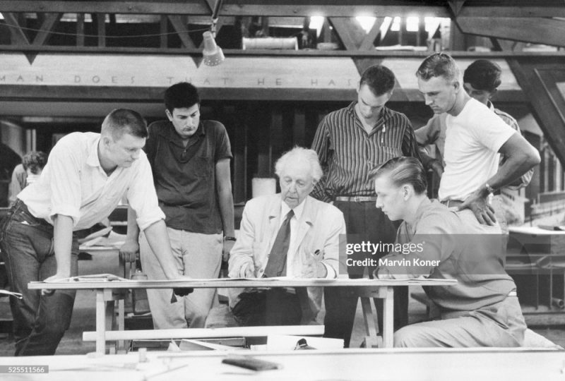 American architect Frank Lloyd Wright (1867-1959) looks over a drawing with his assistants at the Hillside Drafting Studio on the Wright's Taliesin Estate near Spring Green, Wisconsin, c. 1957. (Photo by ? Marvin Koner/CORBIS/Corbis via Getty Images)