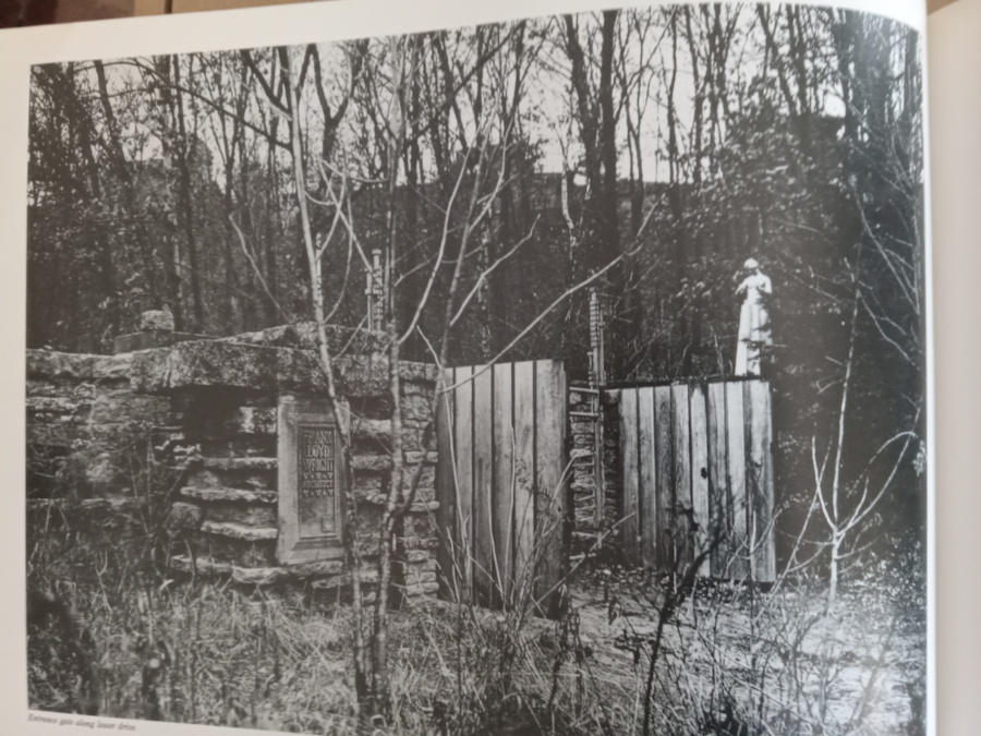 Exterior photograph looking at stone gates at Taliesin with statue "Flower in the Crannied Wall" on the stone gate on the right. Taken from Frank Lloyd Wright: Selected Houses, volume 2, Taliesin