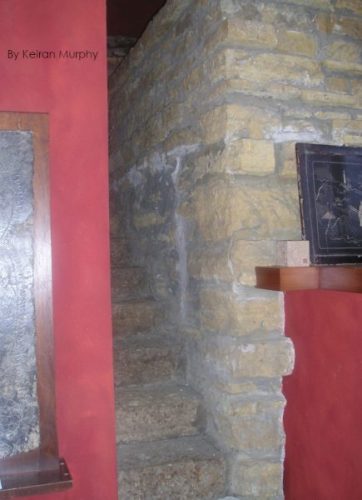 Color photograph with stone wall and steps. And red plaster pier. By Keiran Murphy